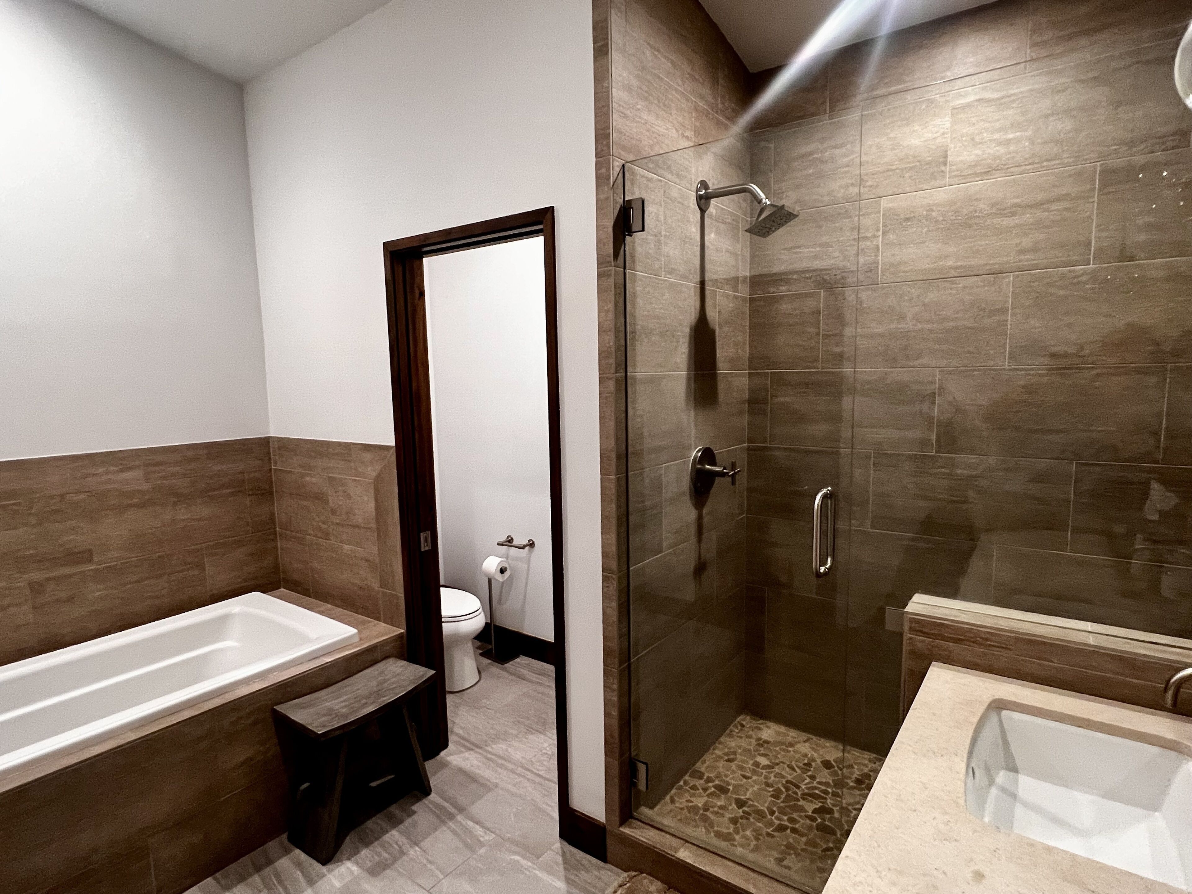 Un baño moderno con bañera, ducha e inodoro.