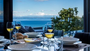 Ein Esstisch mit Blick auf Meer und Berge.
