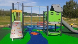 Un parque infantil con tobogán, estructuras para escalar y columpios.