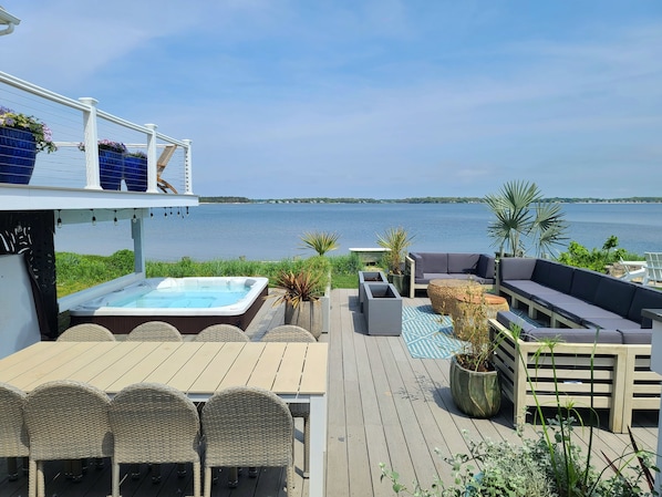 A deck with a hot tub, outdoor seating, and a view of the water. - Hamptons Waterfront Suite Private Hot Tub Winter Escape Adults Only (Flanders)