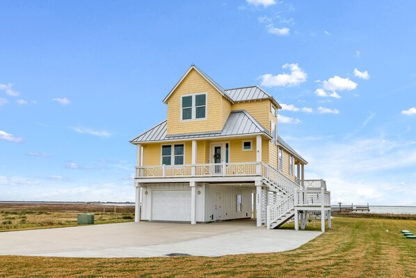 A two-story house with a balcony, a garage, and a staircase leading to the second floor.