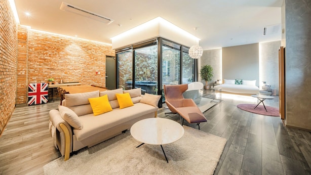 A modern living room with a sofa, coffee table, and a glass partition. - Daegu Eastern Hotel Lions Park (Daegu)