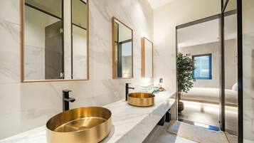 A modern bathroom with two sinks, large mirrors, and a large window.