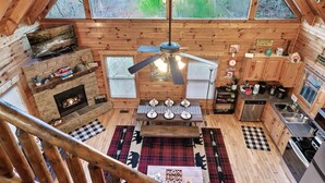 A cozy cabin with a fireplace, a dining area, and a kitchen. - Buddy’s Mountain Hideaway (Sevierville)