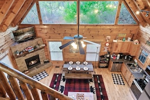 Una cabaña acogedora con chimenea, comedor y cocina.