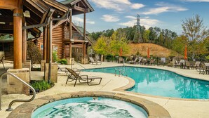 A log cabin-style building with a pool and hot tub area. - Heated Rst Pool-Dollywood-WIFI -Arcade-Parkway-Families-Shopping-Hot Tub-Shows (Pigeon Forge)