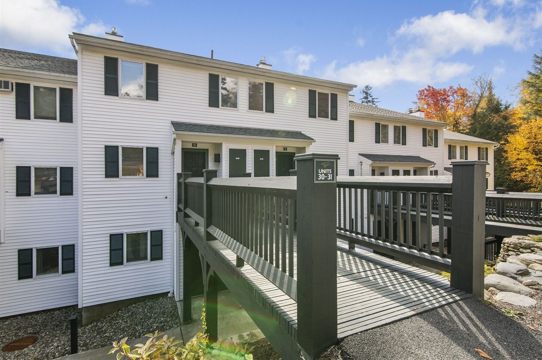 A multi-story residential building with a gated entrance and a small outdoor deck.
