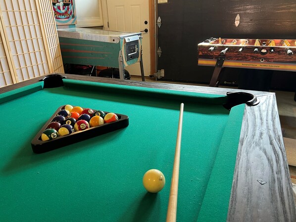 A pool table with balls and a cue stick, a wooden cabinet, and a door with a poster. - Beautiful Modern 4 Bedroom Home Near Stowe Village (Stowe)