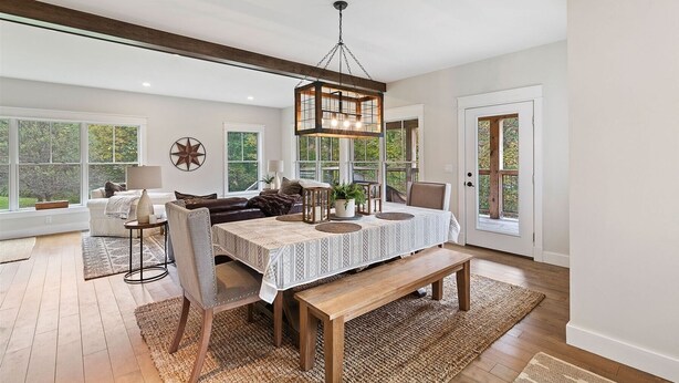 Un espace repas comprenant une table en bois, des chaises et un luminaire suspendu.