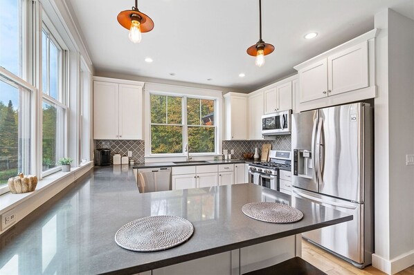 Enjoy cooking in this well-lit kitchen with an oven, microwave, and refrigerator.