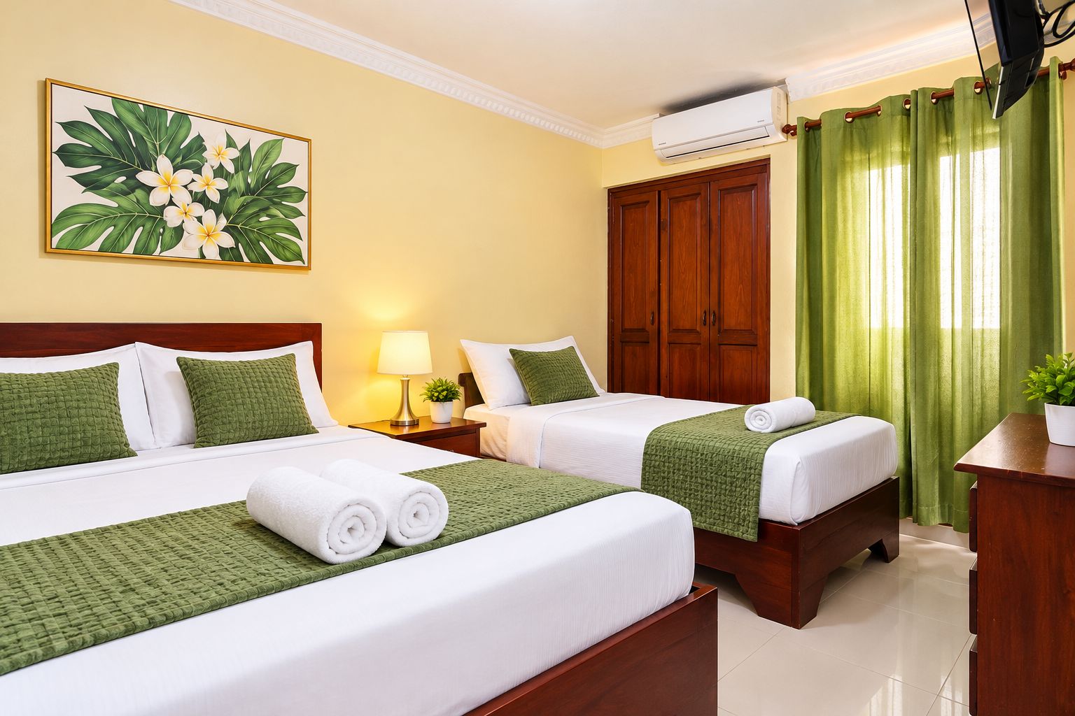 A hotel room with two beds, a painting of tropical flowers, an air conditioning unit, and a green curtain.