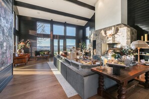 A spacious living room with a stone fireplace, large windows, and a view of the mountains. - Incredible 8 Bedroom Aerie Estate - Minutes to Main Street - Unobstructed Views of Park City (Park City)