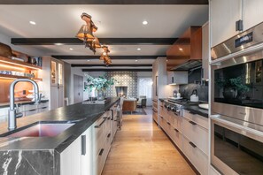 A modern kitchen with a central island, stainless steel appliances, and a wooden floor. - Incredible 8 Bedroom Aerie Estate - Minutes to Main Street - Unobstructed Views of Park City (Park City)