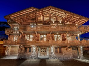 Un immeuble en bois à plusieurs étages, doté de balcons et de grandes fenêtres, et caractérisé par des fondations en pierre.