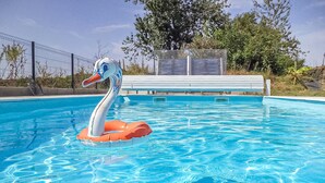 A swimming pool with a swan float and a covered seating area. - Cozy home in La Souterraine (La Souterraine)