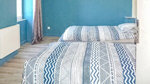 A room with two beds, a window, and a radiator. - Cozy home in La Souterraine (La Souterraine)
