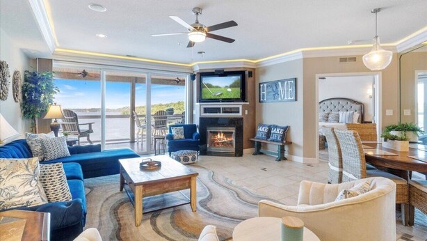 A spacious living room with a fireplace, a television, and a view of the outdoors. - GWEN'S GETAWAY!!, TOP FLOOR! 10 Mile View, Kid Friendly! (Osage Beach)