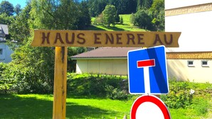 En skylt med texten ”HAUS ENERE AU” och en blåriktningsskylt.