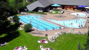 Ett poolområde med flera pooler, solstolar och parasoller.
