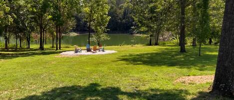 Un espace verdoyant avec quelques sièges et un lac en arrière-plan.