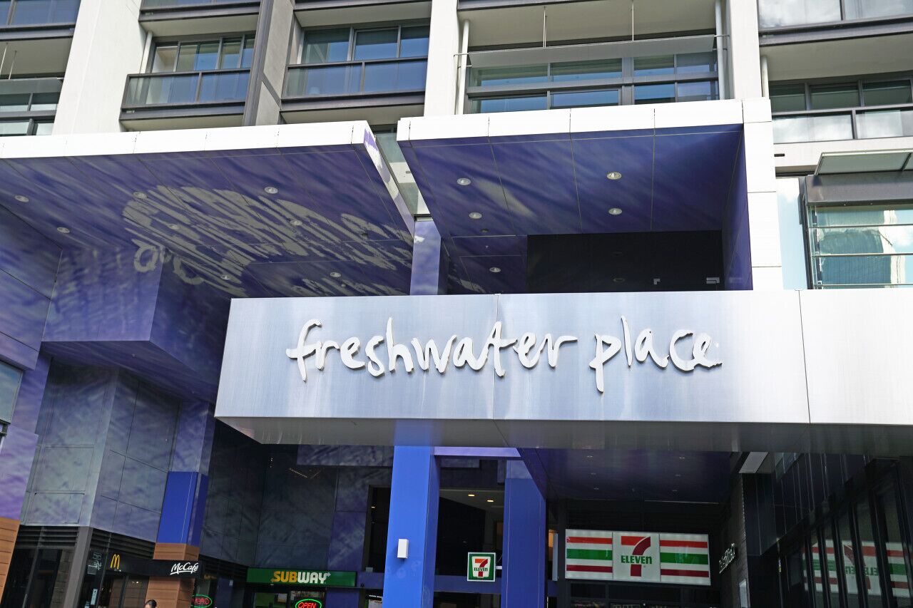 A building with a sign reading 'Freshwater Place' and a 7-Eleven store below.