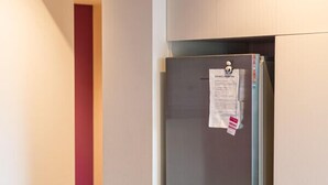 Et moderne køkken med et indbygget, rustfrit stål køleskab, en stikkontakt og en blå stol.