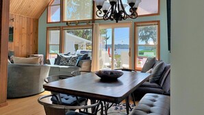 A dining area with a wooden table, chairs, and a chandelier. - Hood Canal "Seaside Chalet". Beautifully updated and decorated.  Lovely setting! (Belfair)