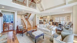 A spacious living area with a staircase, a dining area, and a kitchen.