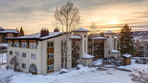 En bygning med flere etager dækket af sne, mod en klar himmel.