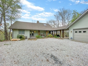 A single-story house with a covered porch, a gravel driveway, and a garage. - Whispering Pines Lakehouse - private dock and free zipline and railroad passes (Bryson City)