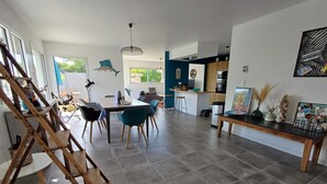 A modern living space with a dining area, kitchen, and a staircase. - 4 * vacation home between La Torche and Pors Carn with swimming pool. (Penmarch)