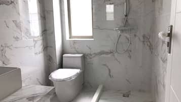 Een bad/douchecombinatie, een bubbelbad, een bidet, handdoeken