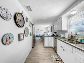 Enjoy cooking in this well-equipped kitchen with a central island, sink, and ample countertop space.