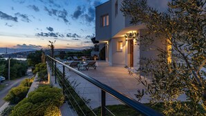 Une maison moderne dotée d’un balcon, d’un espace salon extérieur et offrant une vue sur le paysage.