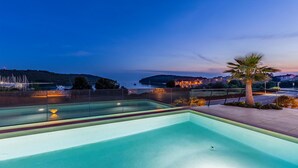 Piscina com vista para a área costeira ao entardecer.