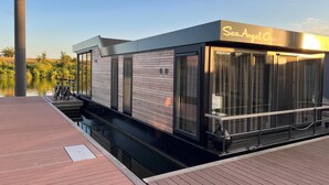 Ein modernes, schiffartiges Gebäude mit einem Schild 'Sea Angel One', das große Fenster und eine Holzfassade hat.