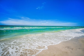 A beach with clear turquoise water and a sandy shore.