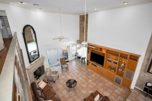 A spacious living area with a fireplace, seating, and a television.