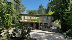 A stone house with a gravel patio, outdoor seating, and a small garden area. - Magnificent restored farmhouse in Crillon-le-Brave with swimming pool  (CRILLON LE BRAVE)