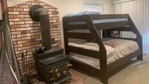 Uma cama de beliche com uma parede de tijolos rústica e uma lareira a lenha.