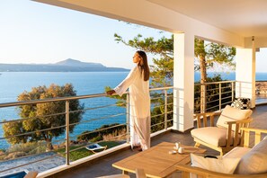A balcony with a view of the sea, a wooden table, and two chairs. - KEA, above the sea, superb views, near beach. (Almyrida)