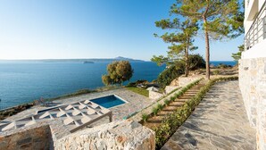 A stone pathway leading to a pool with a view of the sea and a ship in the distance. - KEA, above the sea, superb views, near beach. (Almyrida)