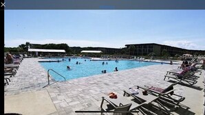 A large outdoor swimming pool with multiple lanes, surrounded by lounge chairs and umbrellas. - Hilton Head First Floor Ocean View with Balcony, Pool, and Tennis (Hilton Head Island)