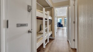 A private room with bunk beds, a door labeled "PRIVATE," and a hallway leading to a balcony. - Hilton Head First Floor Ocean View with Balcony, Pool, and Tennis (Hilton Head Island)
