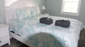 Een slaapkamer met een bed, nachtkastjes en een raam.