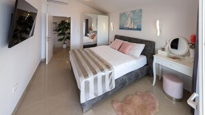 Une chambre à coucher moderne avec un lit, une table de chevet, un miroir et un tableau accroché au mur.