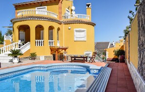 A yellow building with a swimming pool, outdoor seating, and a staircase. - Beautiful home in Orihuela (Orihuela)