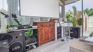 Un système de cinéma maison comprenant un grand écran, du matériel audio et un meuble en bois.