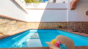 Una piscina amb murs de pedra i un marc de rajola.