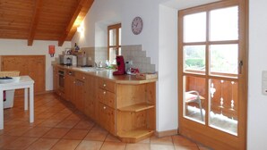 Una cocina con armarios de madera, un lavamanos y un ventanal.